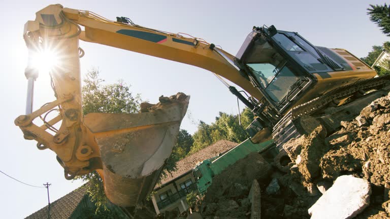 SLO MO Excavator grabbing soil and debris at the construction site in sunshine