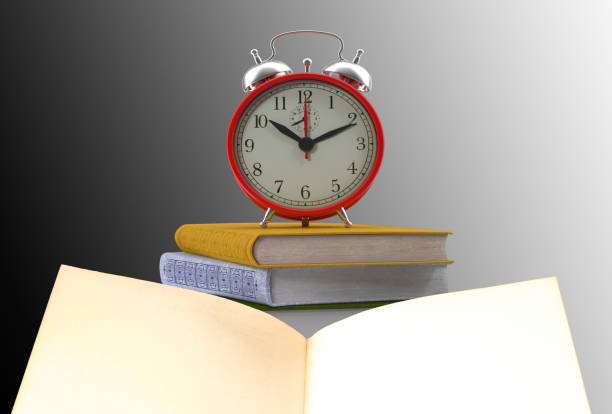 istock Open book and an alarm clock with black and white background 1067518468