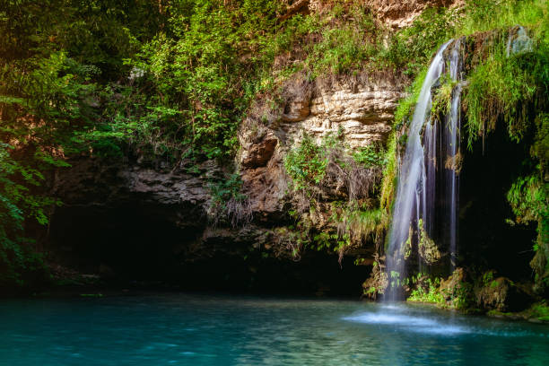 istock Waterfall and a beautiful lagoon lake for relaxing in the summer forest. 1067520914