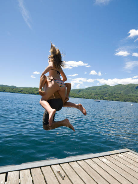 istock Father and daughter jump into lake 1067522730