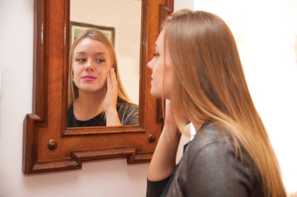 istock Woman looking at mirror and repairing her makeup 1067526936
