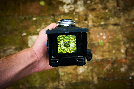 First person view through vintage TLR (Twin lens reflex) camera viewfinder. Selective focus