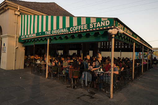 New Orleans, USA - Oct 28, 2018: The famous bustling Cafe Du Monde late in the day. The cafe is famous for its fluffy Beignets and Chicory coffee.