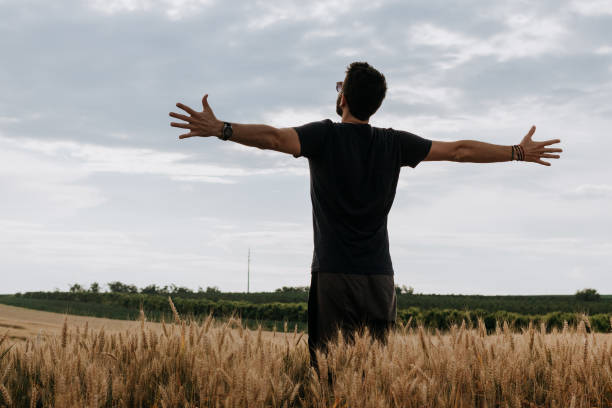 istock Young man in the wheat field with spread arms 1067538390