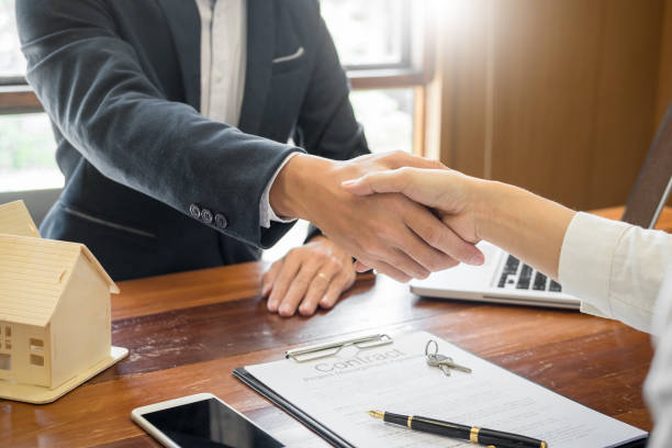 istock Midsection Of Businessman And Customer Shaking Hands Over Table In Office 1067540744
