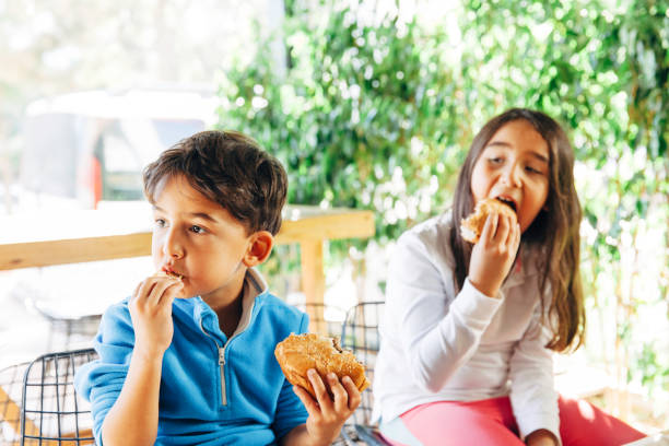 istock Children on in the restaurant eating a burger 1067553932