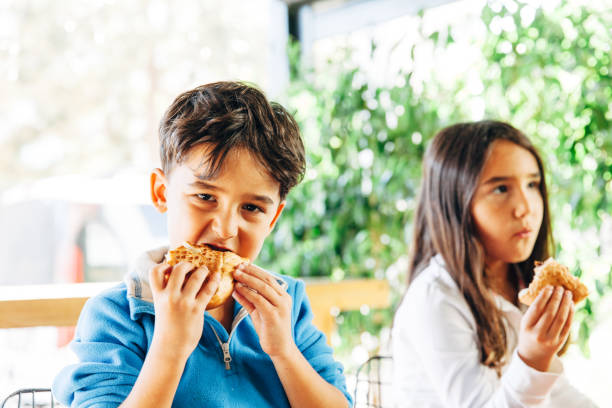 istock Children on in the restaurant eating a burger 1067554698