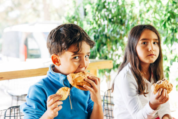 istock Children on in the restaurant eating a burger 1067555042