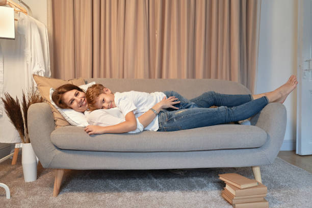 istock Mother and son lying on the sofa while hugging each other 1067555448