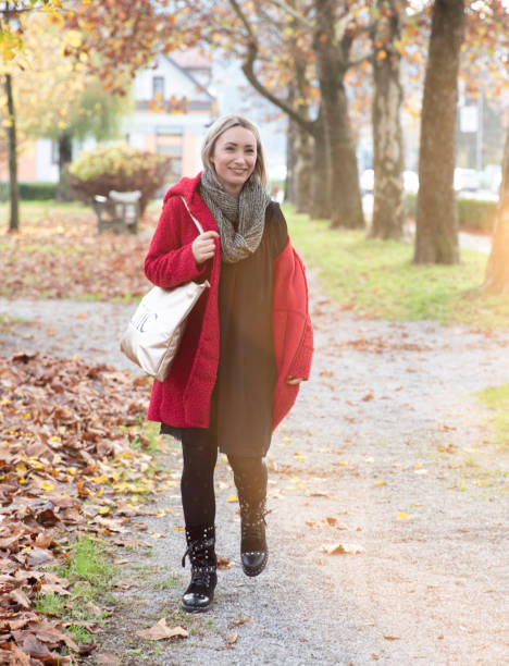 istock Beautiful young woman walking in a park 1067555510