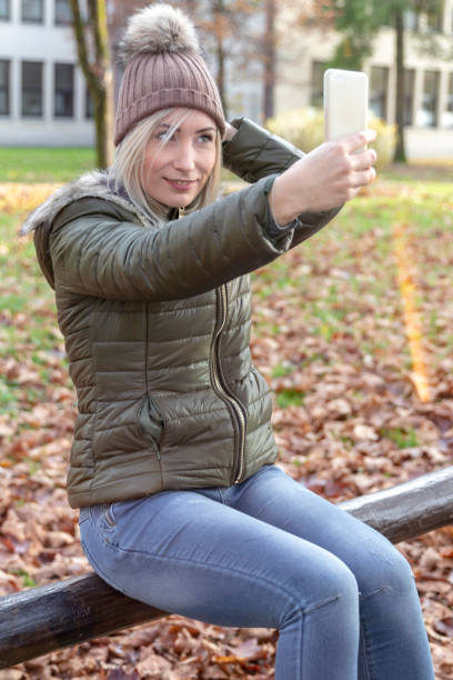 istock Young blond woman making selfies in a park 1067555518