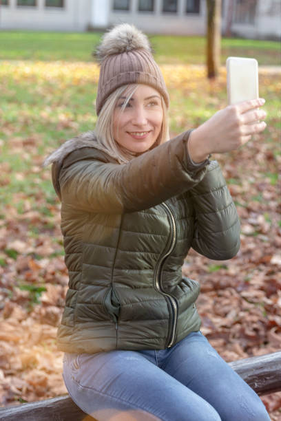 istock Young blond woman making selfies in a park 1067555550
