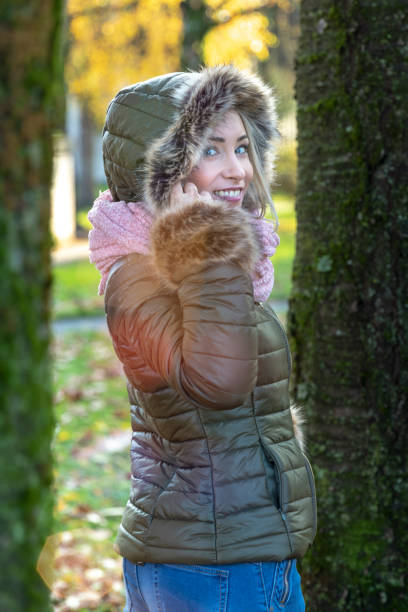 istock Woman walking between trees in a park on sunny autumn day 1067556904