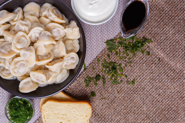 boiled dumplings national dish of many nations with sour cream, soy sauce and greens - fotografia de stock