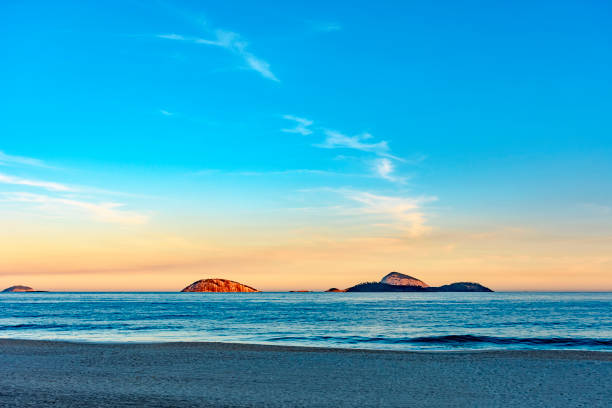 Sunset at Ipanema beach, Rio de Janeiro. Stone of Gavea and Two Brothers mountains.