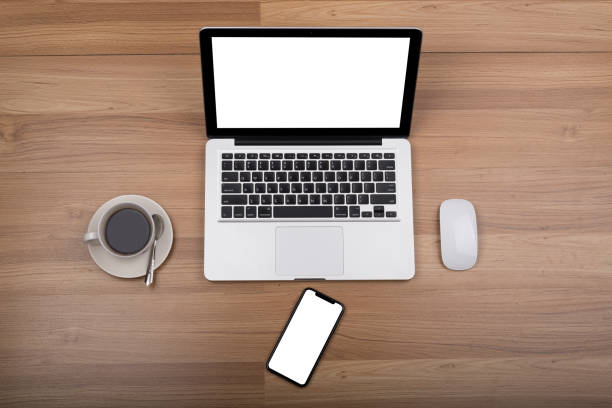 istock laptop, smartphone and coffee cup on wooden table with office equipment 1067569014