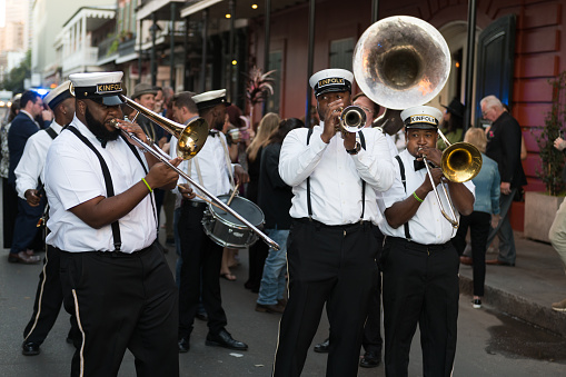 New Orleans, USA - Nov 3, 2018: A Second Line moving down Bourbon street in the french quarter late in the day.