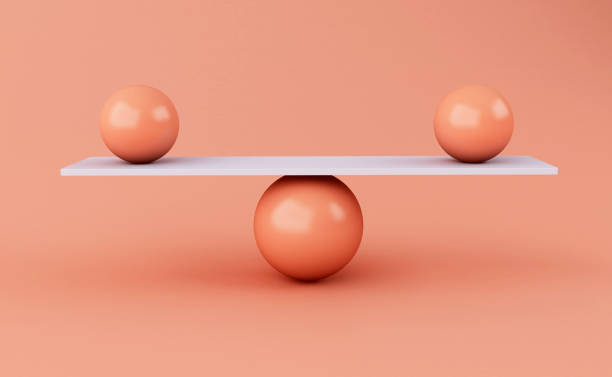 istock 3d spheres balancing on a seesaw. 1067573450