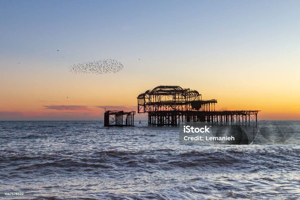 Brighton Sunset Sunset at Brighton Beach, with a Murmuration of Starlings Beside the Old West Pier Hove Stock Photo