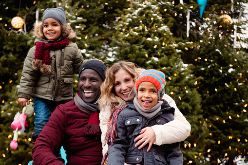 Christmas shopping with a african american dad and a caucasian ethnicity mother and their two mixed race children. They have the pleasure of spending a day together in Old Champlain in Quebec Canada. They enter the shops, walk down the street and have a good meal in a restaurant.