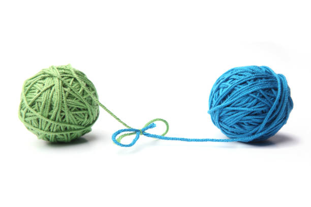 istock Two green and blue cotton thread balls tied in bow isolated on white background. 1067602852