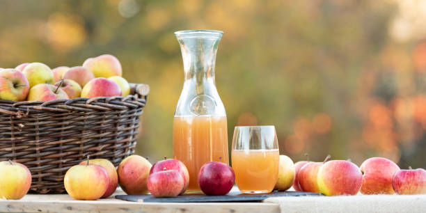 Fresh apple juice from apples in the fall after harvest, served on a table Fresh apple juice from apples in the fall after harvest, served on a table apple juice photos stock pictures, royalty-free photos & images