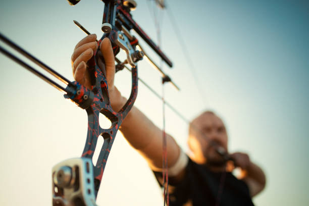 istock Man with prosthetic arm doing archery outdoors 1067608544