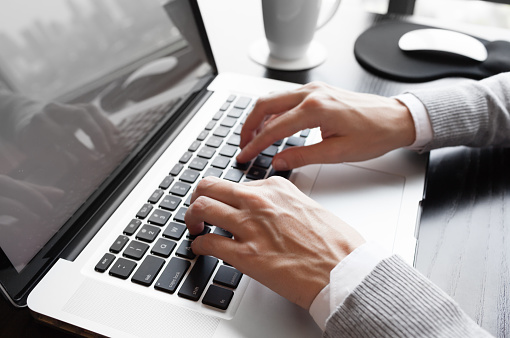 Businesswoman typing on her laptop computer in the office.