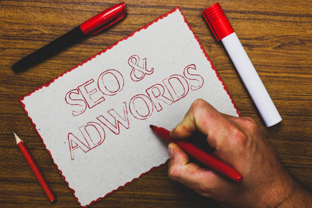 word writing text seo and adwords. business concept for pay per click digital marketing google adsense man hand holding marker notebook paper expressing ideas wooden background. - adsense imagens e fotografias de stock