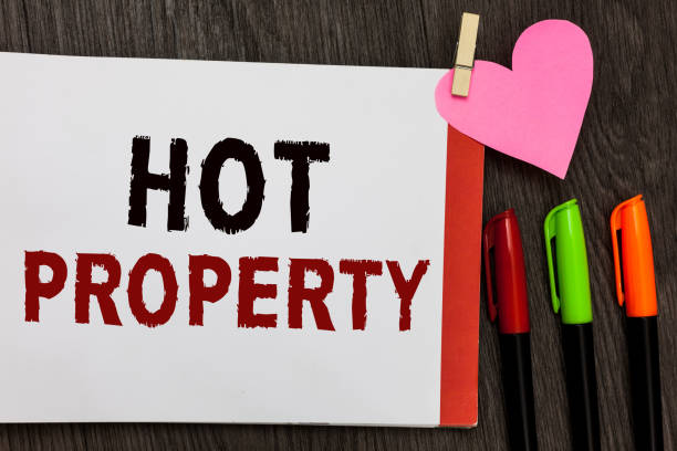 istock Word writing text Hot Property. Business concept for Something which is sought after or is Heavily Demanded Open notebook page markers clothespin holding paper heart wooden background. 1067624974