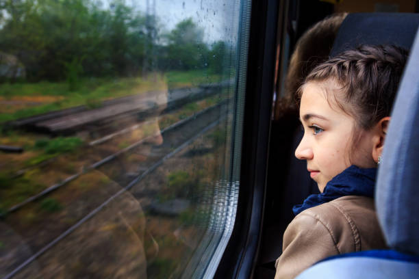 istock Little girl looking through window with reflections. 1067625068