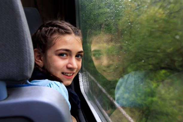 istock Little girl looking through window with reflections. 1067625070