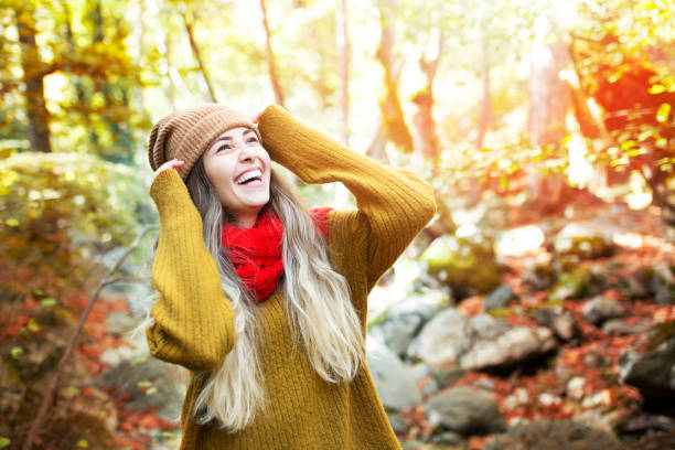 若い幸せな女性は森の中で微笑む - autumn women smiling leaf ストックフォトと画像