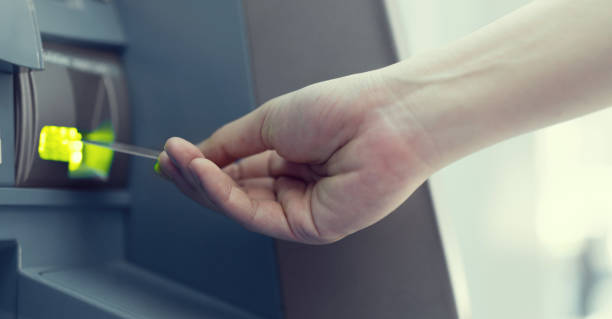 istock close up man hand  insert or pull out debit card on  atm machine for withdraw or deposit money (cash) , business concept 1067627988
