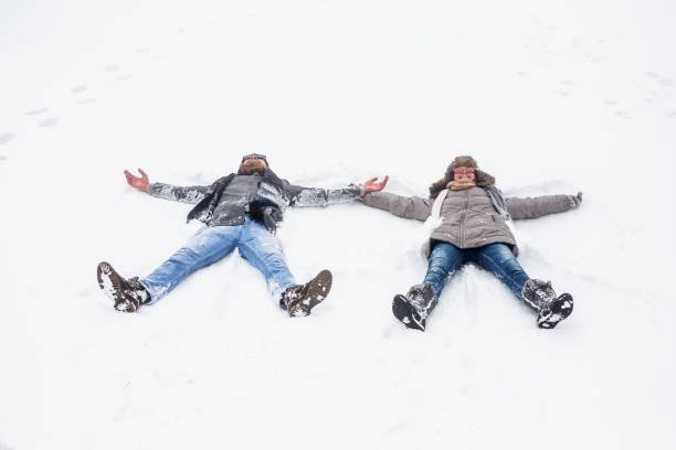 istock Young couple making snow angels outdoors 1067635718