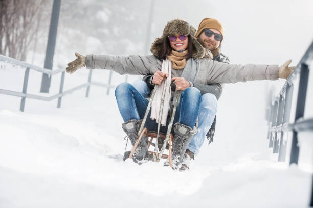 istock Young couple riding sled in snow 1067637540