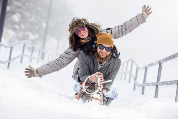 istock Young happy couple riding sled in snow 1067637772