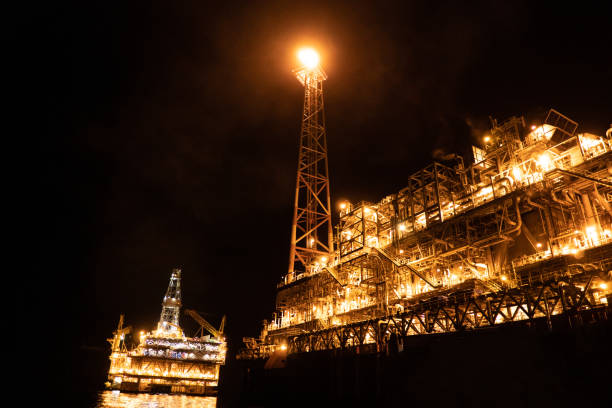 fpso tankowiec statek w pobliżu platformy wiertniczej rig w nocy. morski przemysł naftowy i gazowy - construction platform sea drill mining zdjęcia i obrazy z banku zdjęć