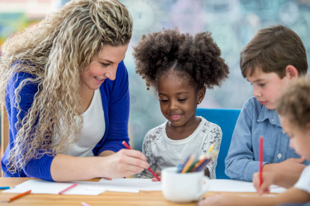 istock A teacher helps young students with drawing 1067648462