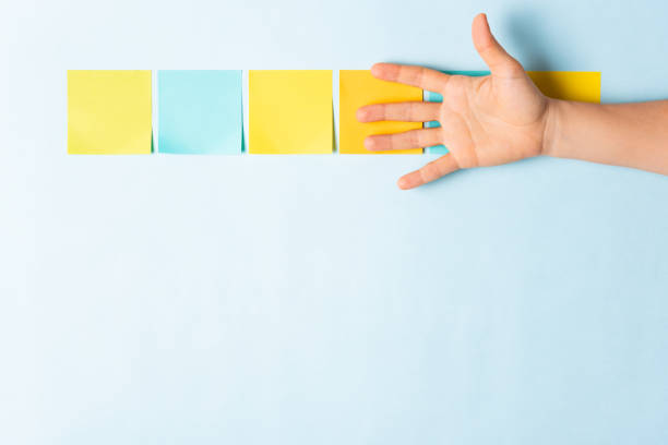 istock Announcement concept with collection of different colored sticky note papers with curled corner, open palm hand hidden three notes and empty three notes. 1067652726
