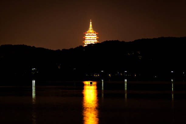 night scenery view of west lake (Hangzhou, China) with Leifeng Pagoda and its lights in the background.  The lighting of Leifeng Pagoda causes beautiful reflection on the lake.