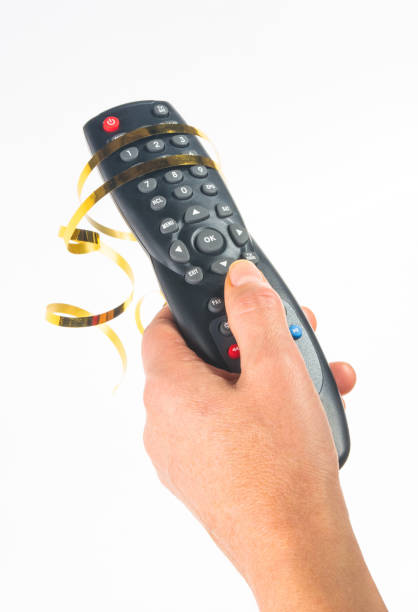 istock hand holding a remote control on white background, close-up 1067671284