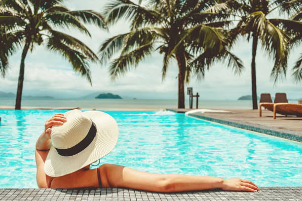 Carefree woman relaxation in swimming pool summer Holiday concept Carefree woman relaxation in swimming pool summer Holiday concept coconut palm tree photos stock pictures, royalty-free photos & images