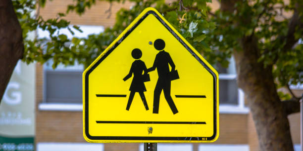 istock School zone road sign with trees and buildings 1067685988