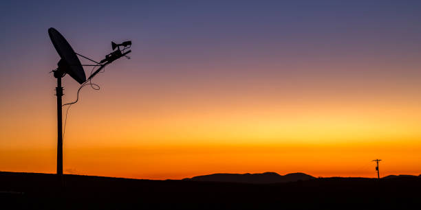 istock Silhouette of satellite and power line at sunset 1067685990