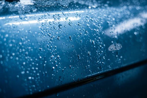 istock Water drops on the surface of a blue car in cold colors 1067690832