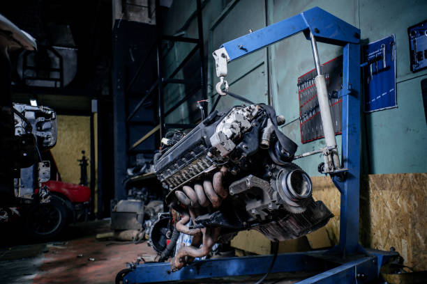 Engine instalation on blue crane hook on car repair service