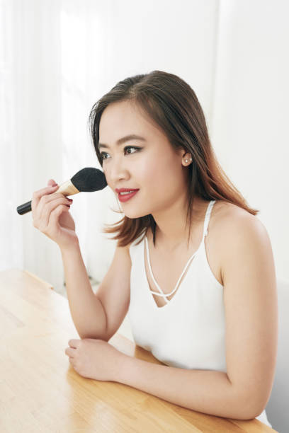 istock Woman applying blush 1067694212