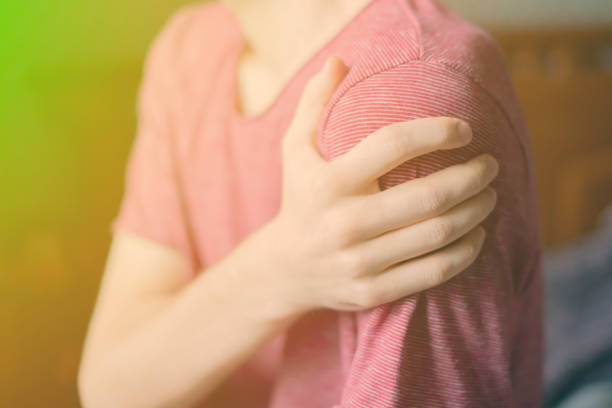 istock close up hand touching shoulder, feeling bone pain f 1067694702