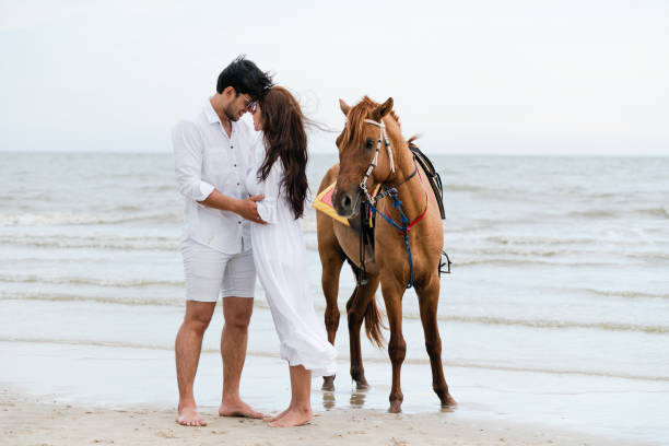 istock Young couple goes horse riding on tropical beach. 1067710026